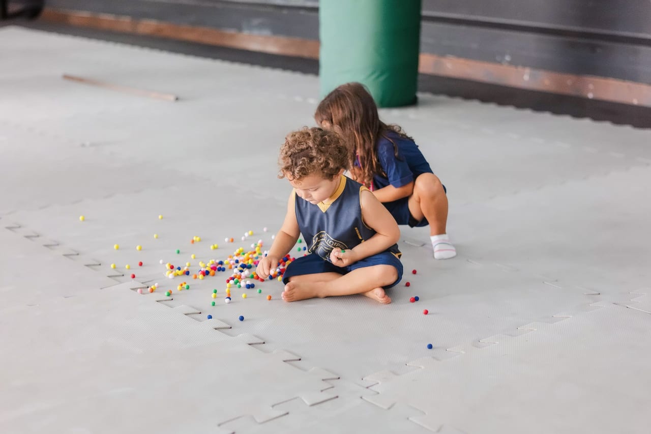 Crianças da Educação Infantil explorando um jogo matemático com peças coloridas
