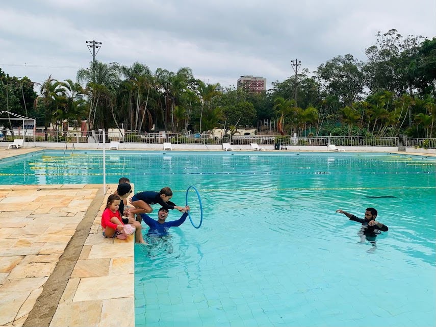 Crianças participando de atividade de natação em piscina